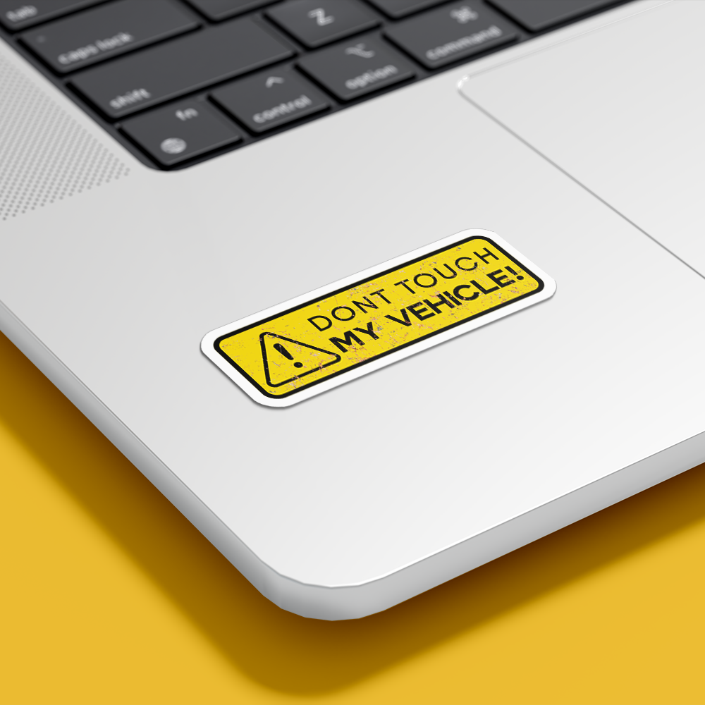 DecorEdge dont touch my vehicle sticker in yellow and black placed on silver laptop